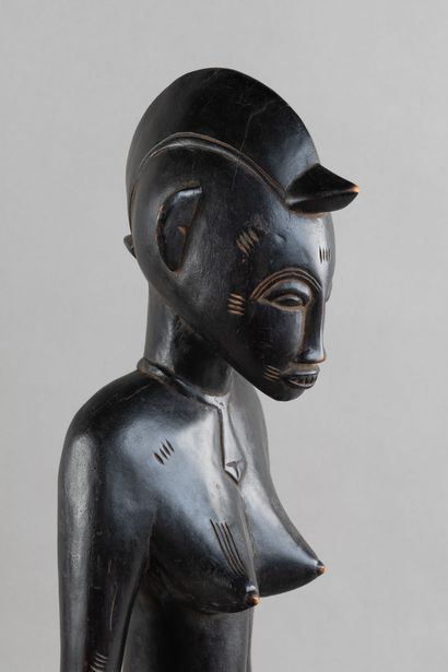 A female figurine depicted sitting on a stool....