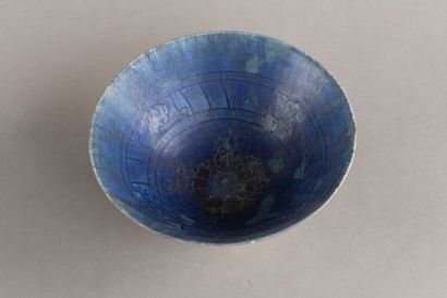 A cobalt-blue ceramic cup decorated with...