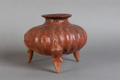 A tripod vase shaped like a pumpkin, resting...