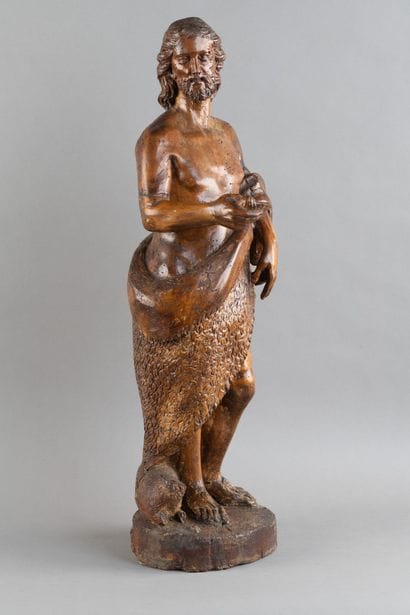 A carved wooden statue of Saint John the...