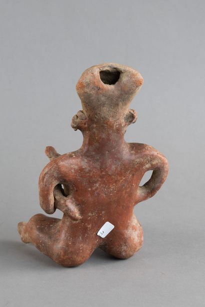 A mother is depicted seated, holding her...
