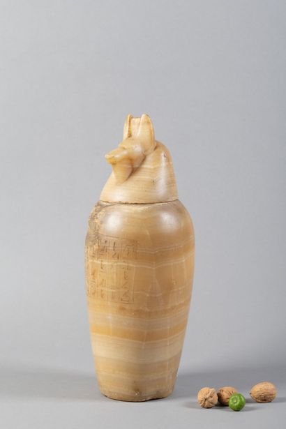 A canopic jar whose body is engraved with...