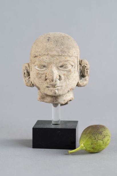 Head of a statuette. It wears a cap and a...