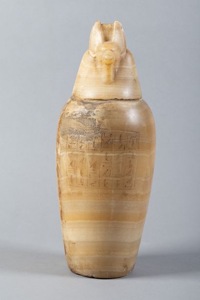 A canopic jar whose body is engraved with...