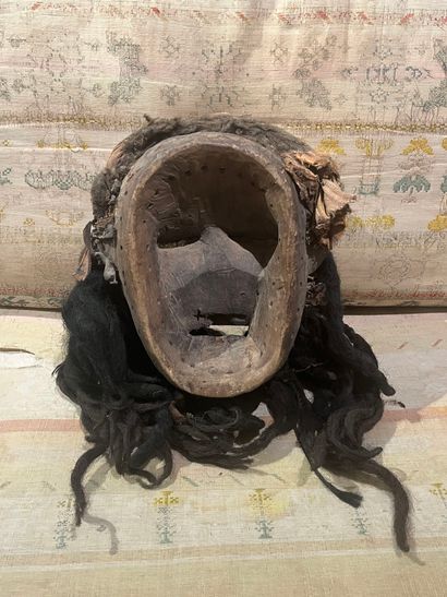 A human-faced dance mask featuring a slightly...