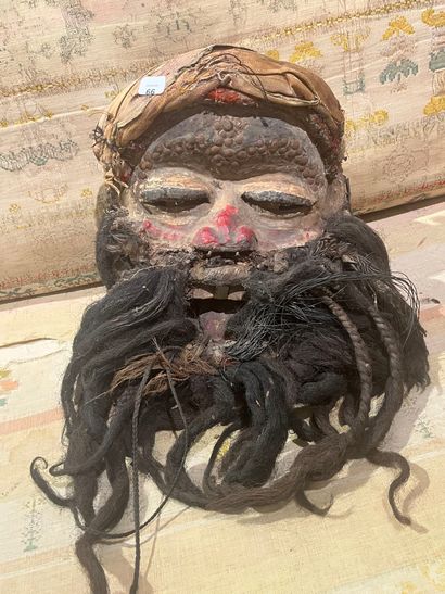 A human-faced dance mask featuring a slightly...