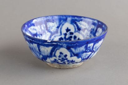 A hollow ceramic cup decorated with four...