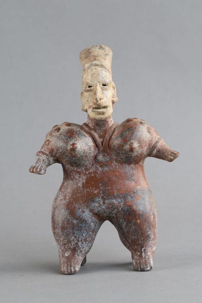 Statuette of a standing woman. She wears...