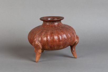 A tripod vase shaped like a pumpkin, resting...