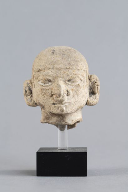 Head of a statuette. It wears a cap and a...