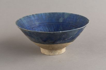 A cobalt-blue ceramic cup decorated with...