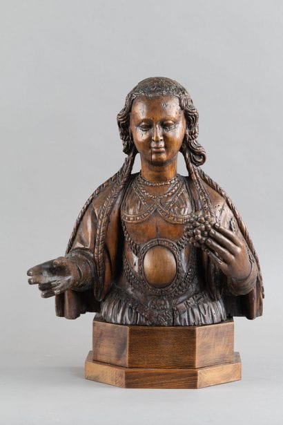 Carved wooden bust of a saintly woman. She...