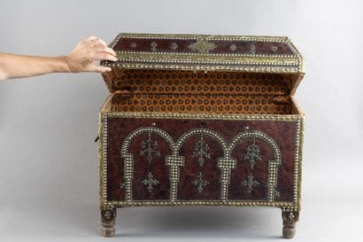 Leather-covered chest with a studded design...
