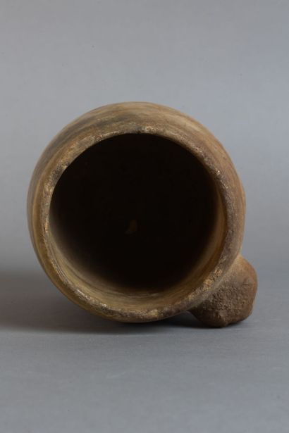 A rounded vase resting on four feet, carved...