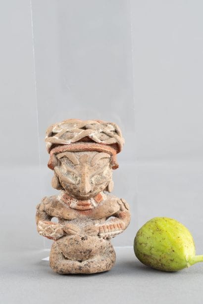 Female statuette depicted seated and pregnant,...