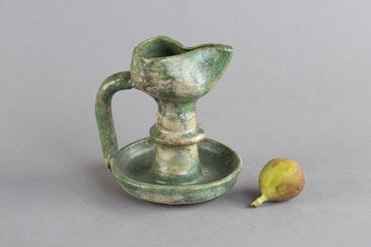 Green ceramic oil lamp with a tall stem and...