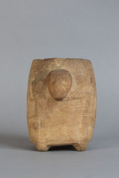 A rounded vase resting on four feet, carved...