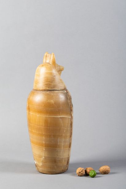 A canopic jar whose body is engraved with...