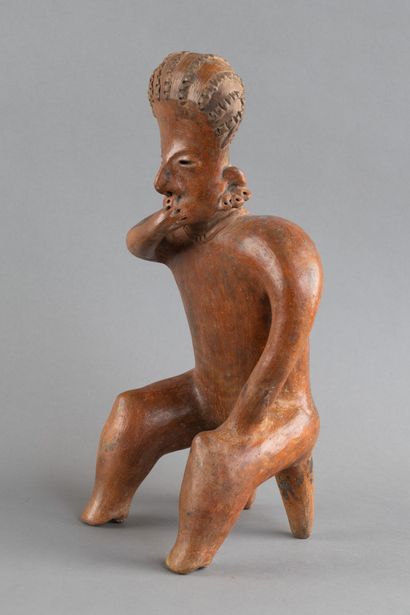 A statuette depicted sitting on a stool....