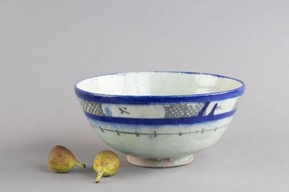 A hollow ceramic bowl decorated with blue-and-white...