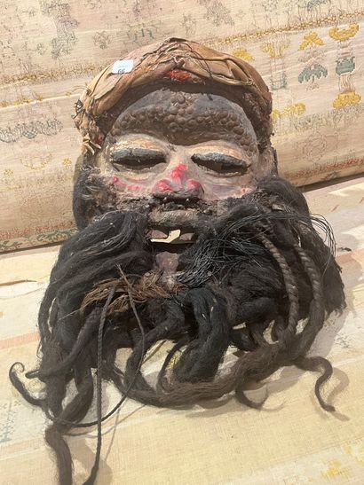 A human-faced dance mask featuring a slightly...