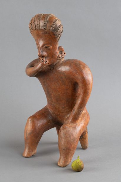 A statuette depicted sitting on a stool....