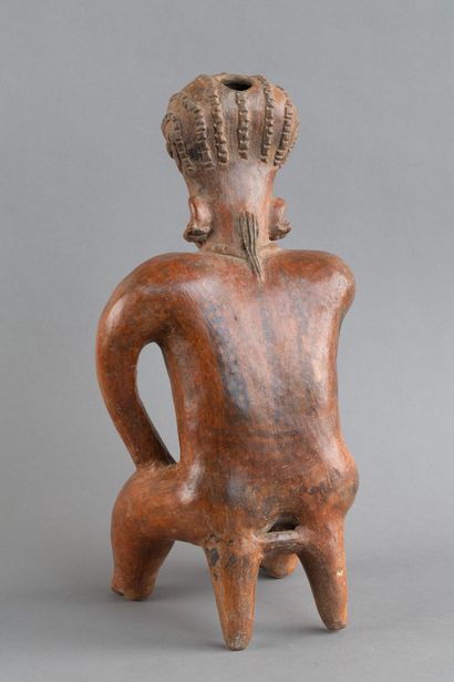 A statuette depicted sitting on a stool....