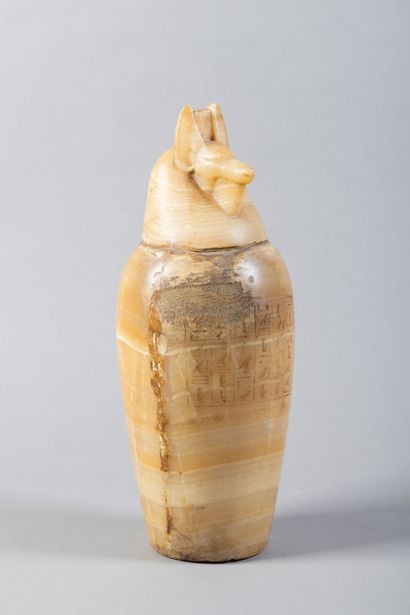 A canopic jar whose body is engraved with...
