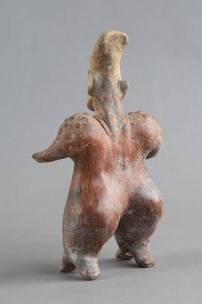 Statuette of a standing woman. She wears...