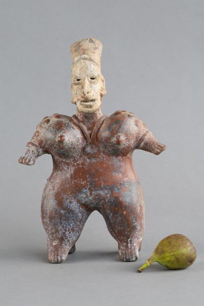 Statuette of a standing woman. She wears...