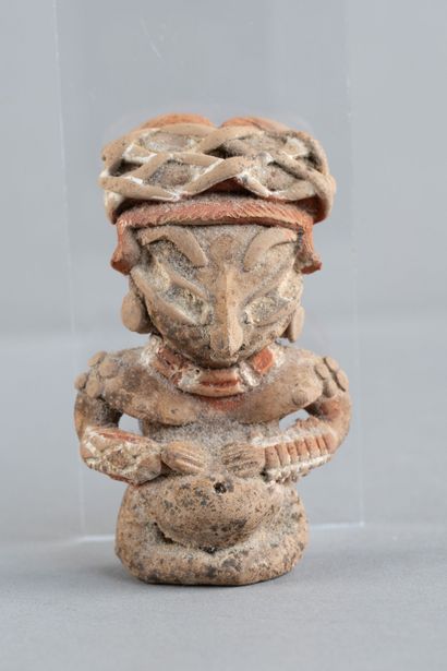 Female statuette depicted seated and pregnant,...