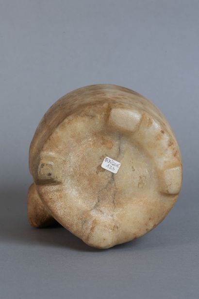 A rounded vase resting on four feet, carved...