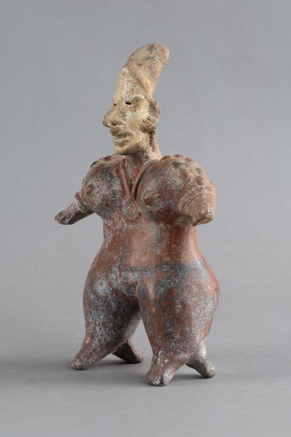 Statuette of a standing woman. She wears...