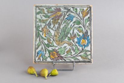 Ceramic tile decorated with a bird entwined...