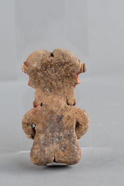 Female figurine depicted seated, holding...