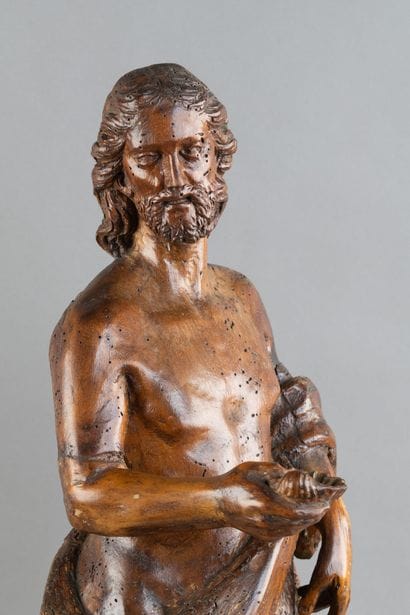 A carved wooden statue of Saint John the...
