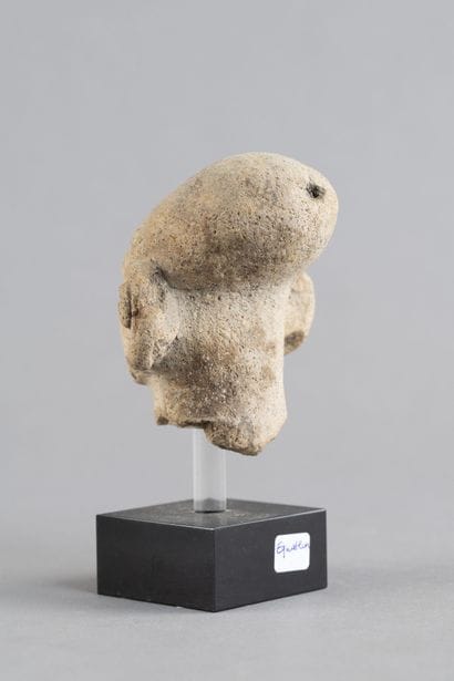 Head of a statuette. It wears a cap and a...