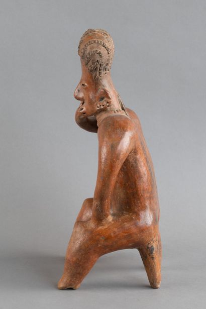 A statuette depicted sitting on a stool....