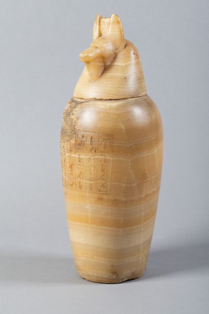 A canopic jar whose body is engraved with...