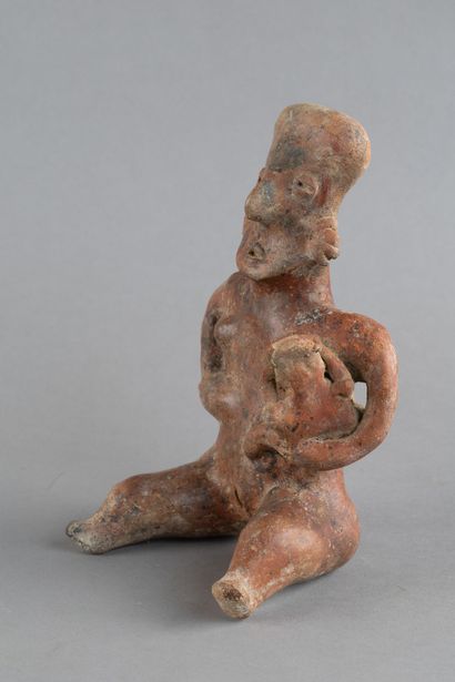 A mother is depicted seated, holding her...