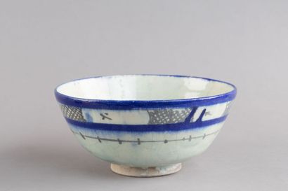 A hollow ceramic bowl decorated with blue-and-white...