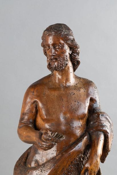 A carved wooden statue of Saint John the...