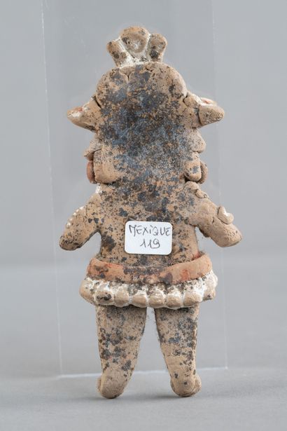 Statuette of a standing woman. She is adorned...