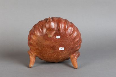 A tripod vase shaped like a pumpkin, resting...