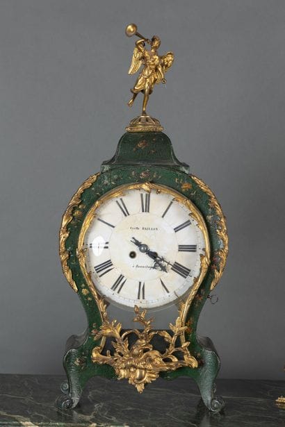 A clock with a lacquered wooden base decorated...