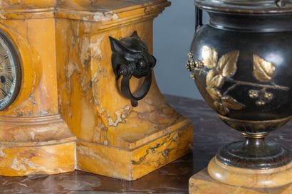A clock and a pair of oil lamps in patinated...