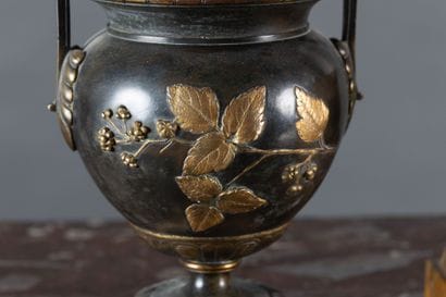 A clock and a pair of oil lamps in patinated...