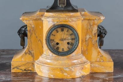 A clock and a pair of oil lamps in patinated...