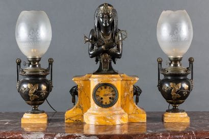 A clock and a pair of oil lamps in patinated...