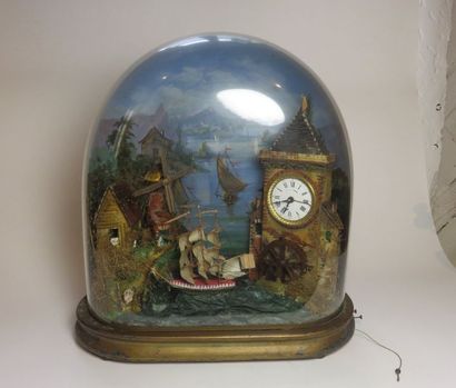 Pendule automate sous globe. A droite, un...